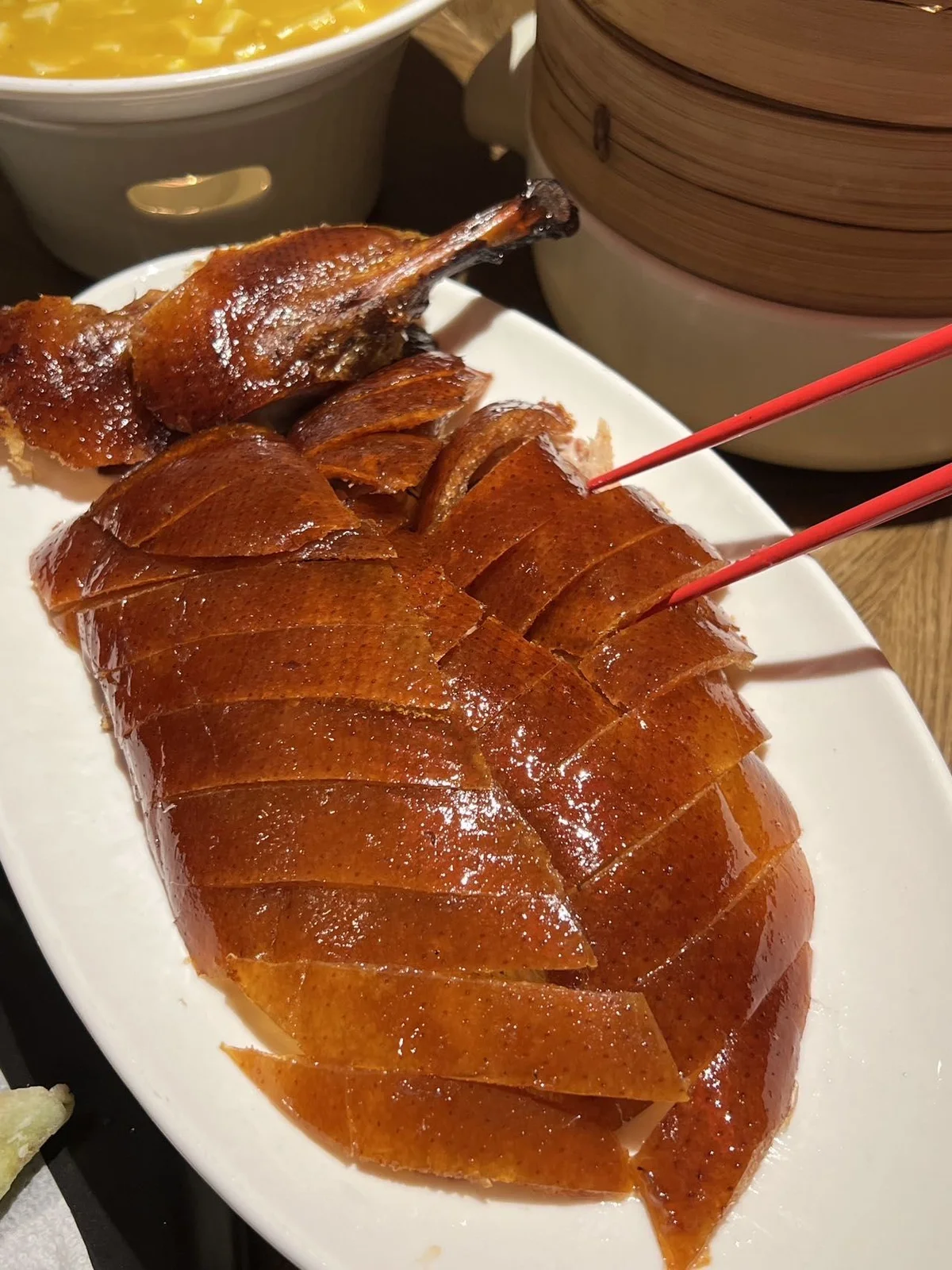 Sliced Peking Duck with glossy crispy skin served on a plate in a Beijing restaurant.