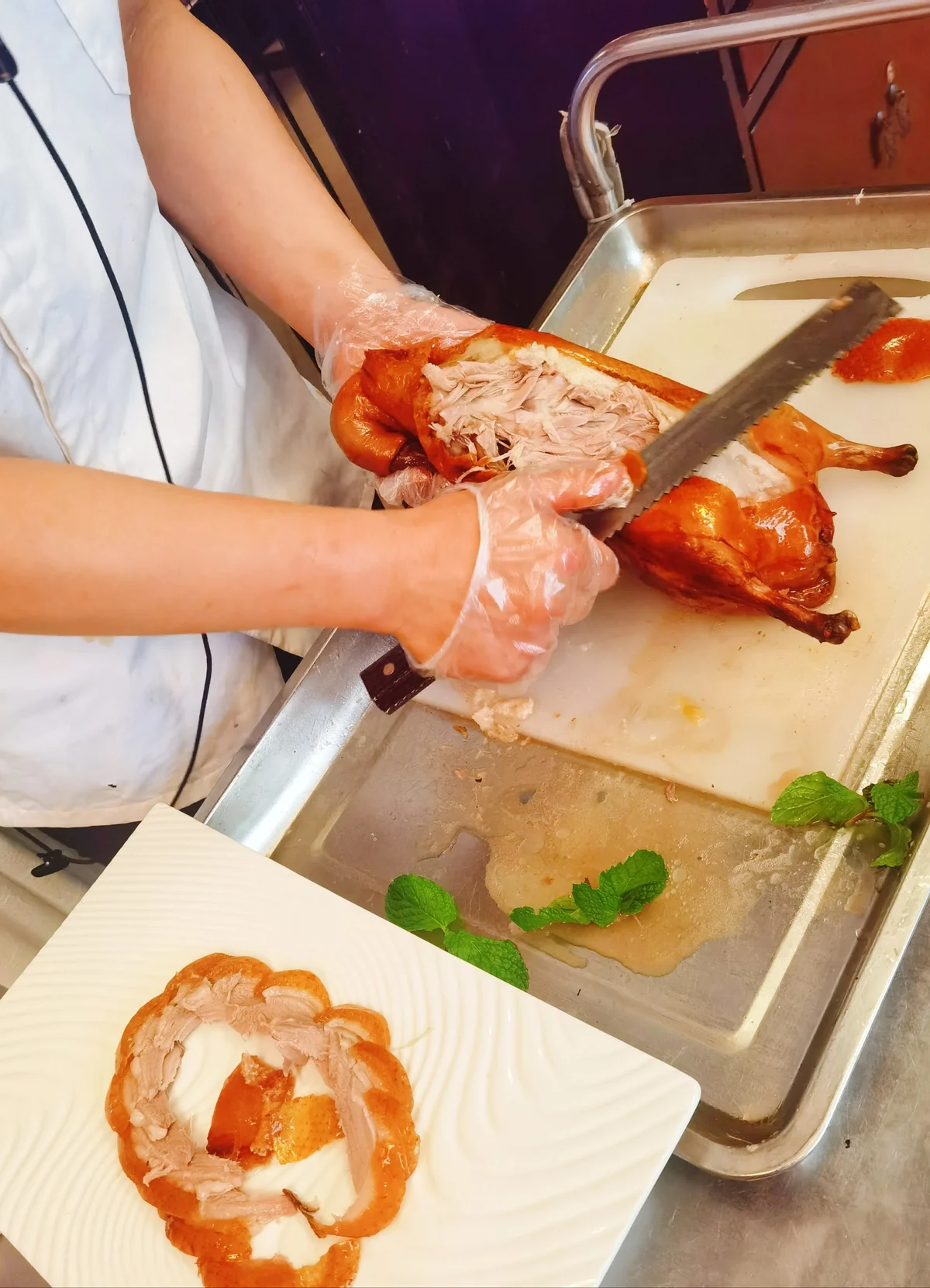 Carving Peking Duck to separate crispy skin and tender meat for serving.