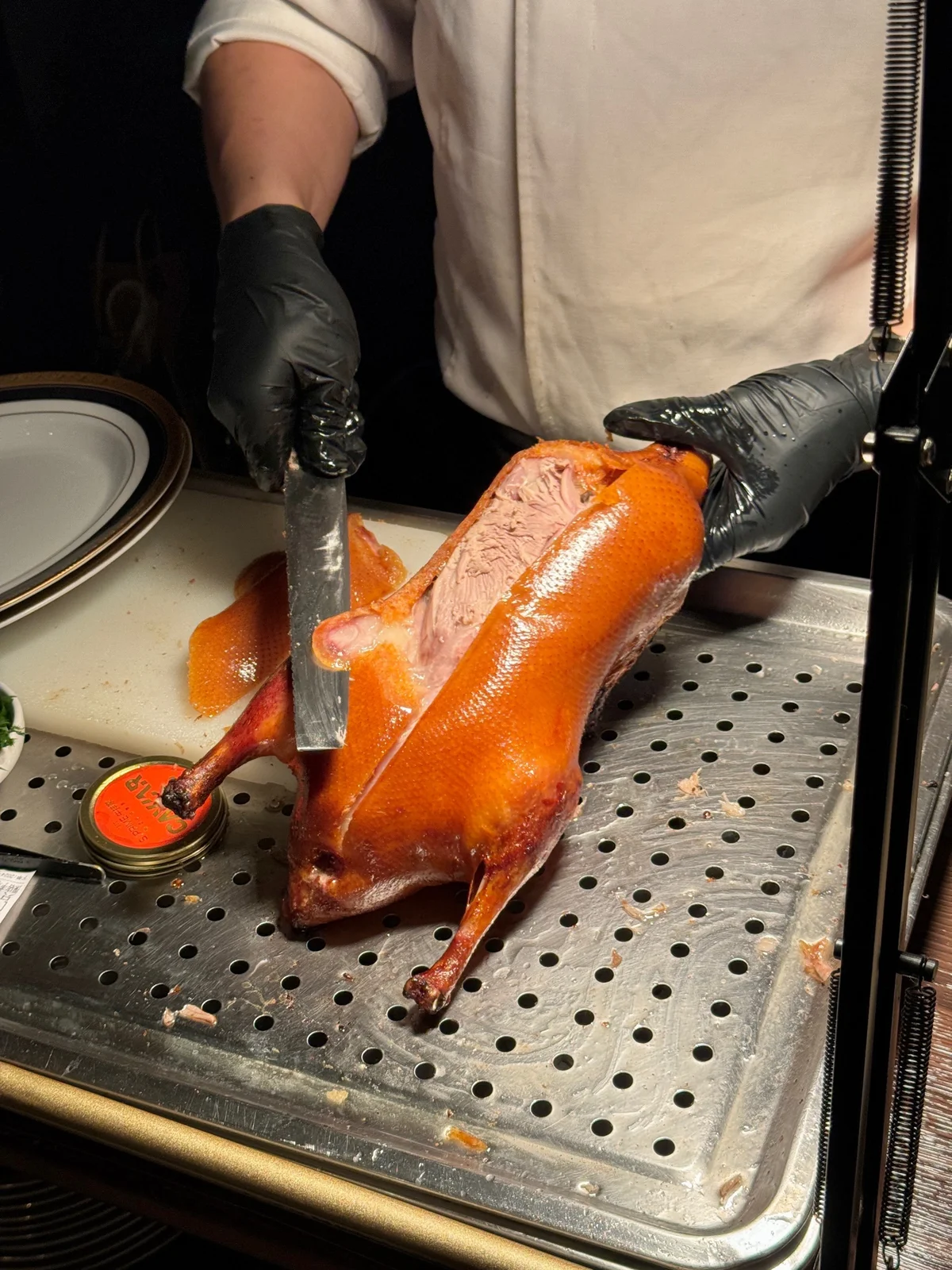 Precise slicing of Peking Duck to create uniform pieces with crisp skin.