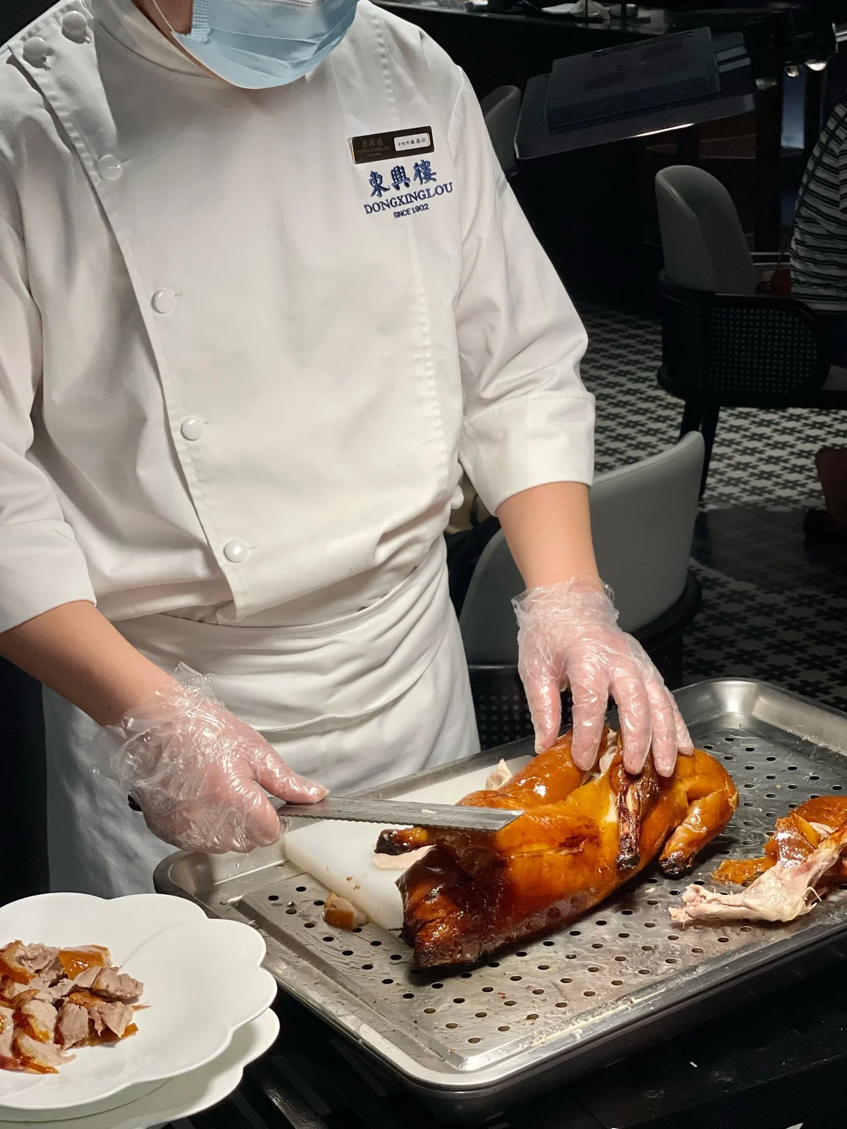 Chef carving whole Peking Duck at Dongxinglou to prepare thin, even slices.