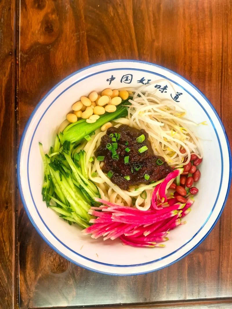 Beijing Zhajiang Noodles with assorted shredded toppings and traditional fried soybean paste.