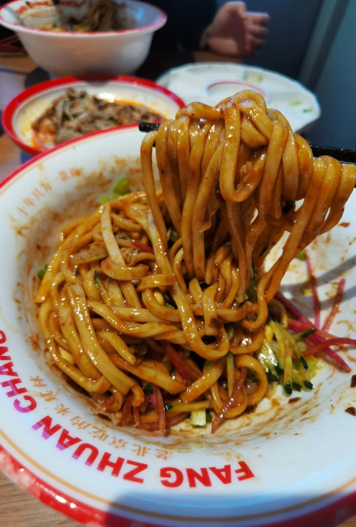 Beijing Zhajiang Noodles fully mixed with thick soybean paste and vegetables.