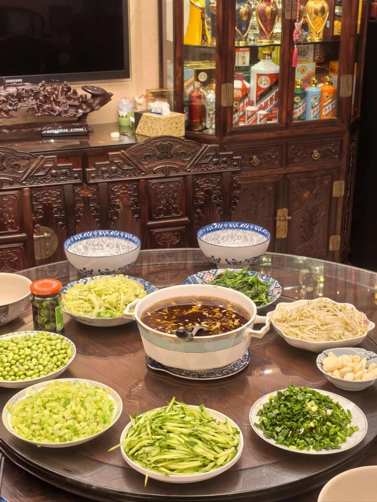 A home-style Beijing table set with Zhajiang Noodles and abundant toppings, showing how the dish is shared during family gatherings.