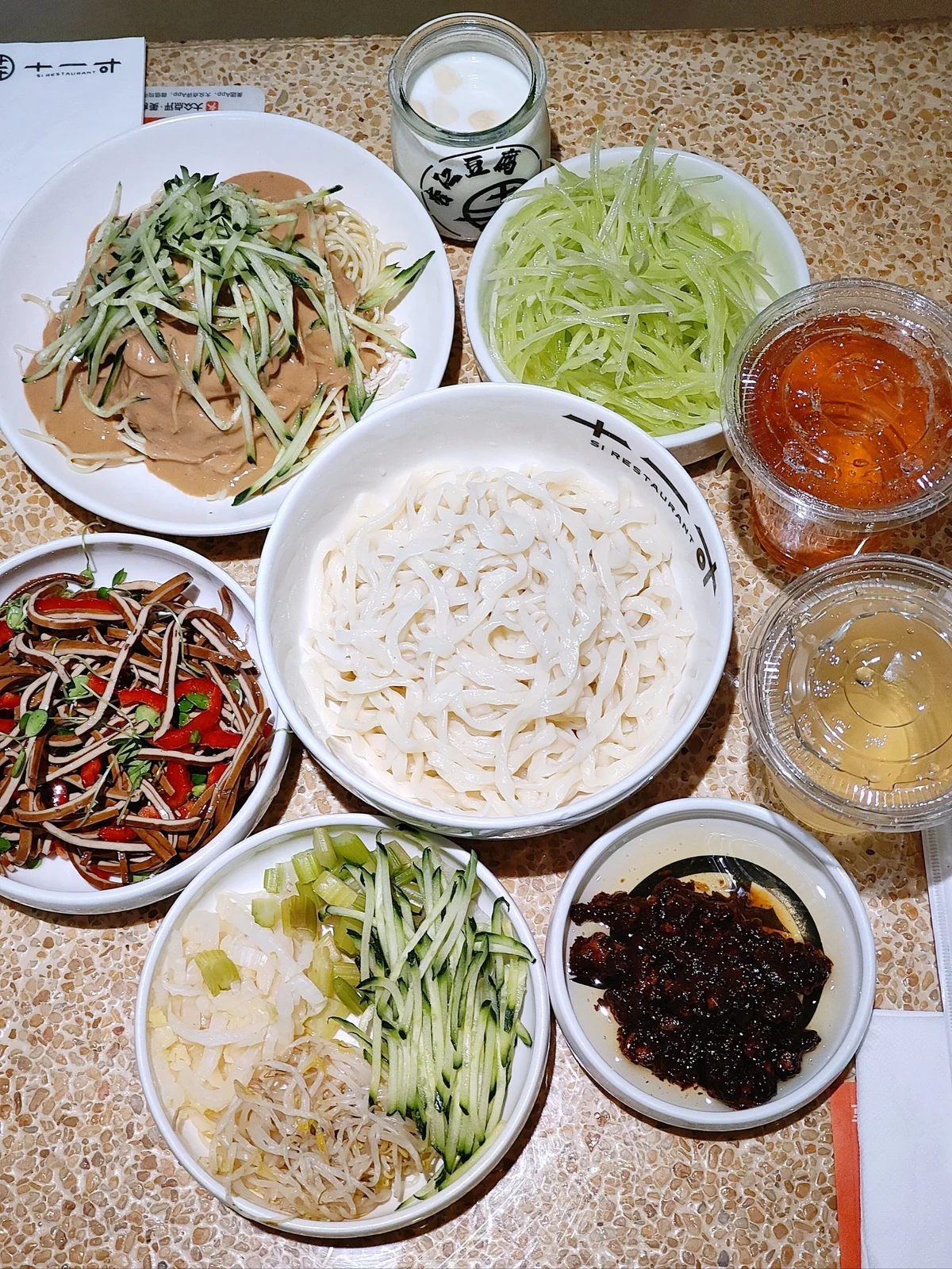 Zhajiang Noodles with a variety of traditional Beijing toppings, emphasizing the dish’s comforting and familiar presence in local cuisine.