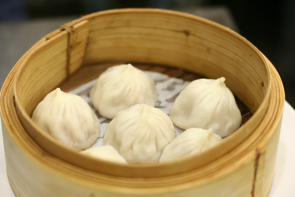 Close-up of steamed pork baozi in a bamboo basket