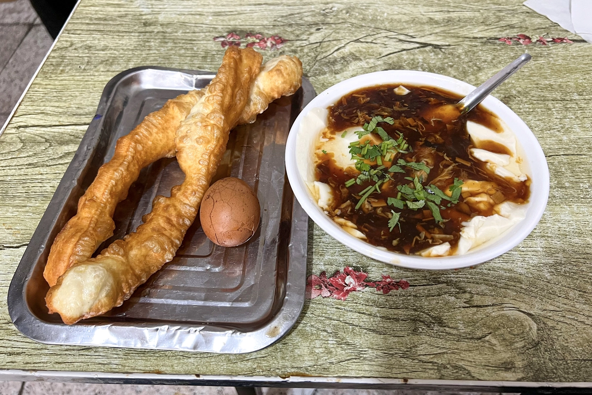 Northern Chinese breakfast with youtiao, tofu pudding, and tea egg