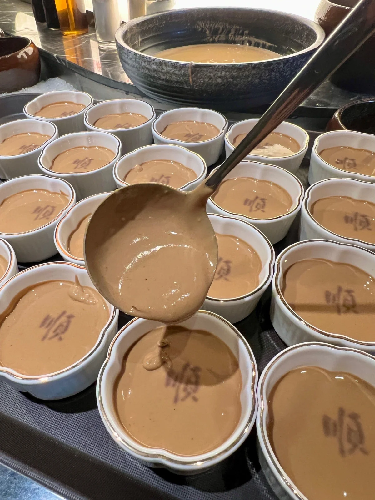 Bowls of sesame paste dipping sauce prepared for Beijing hotpot
