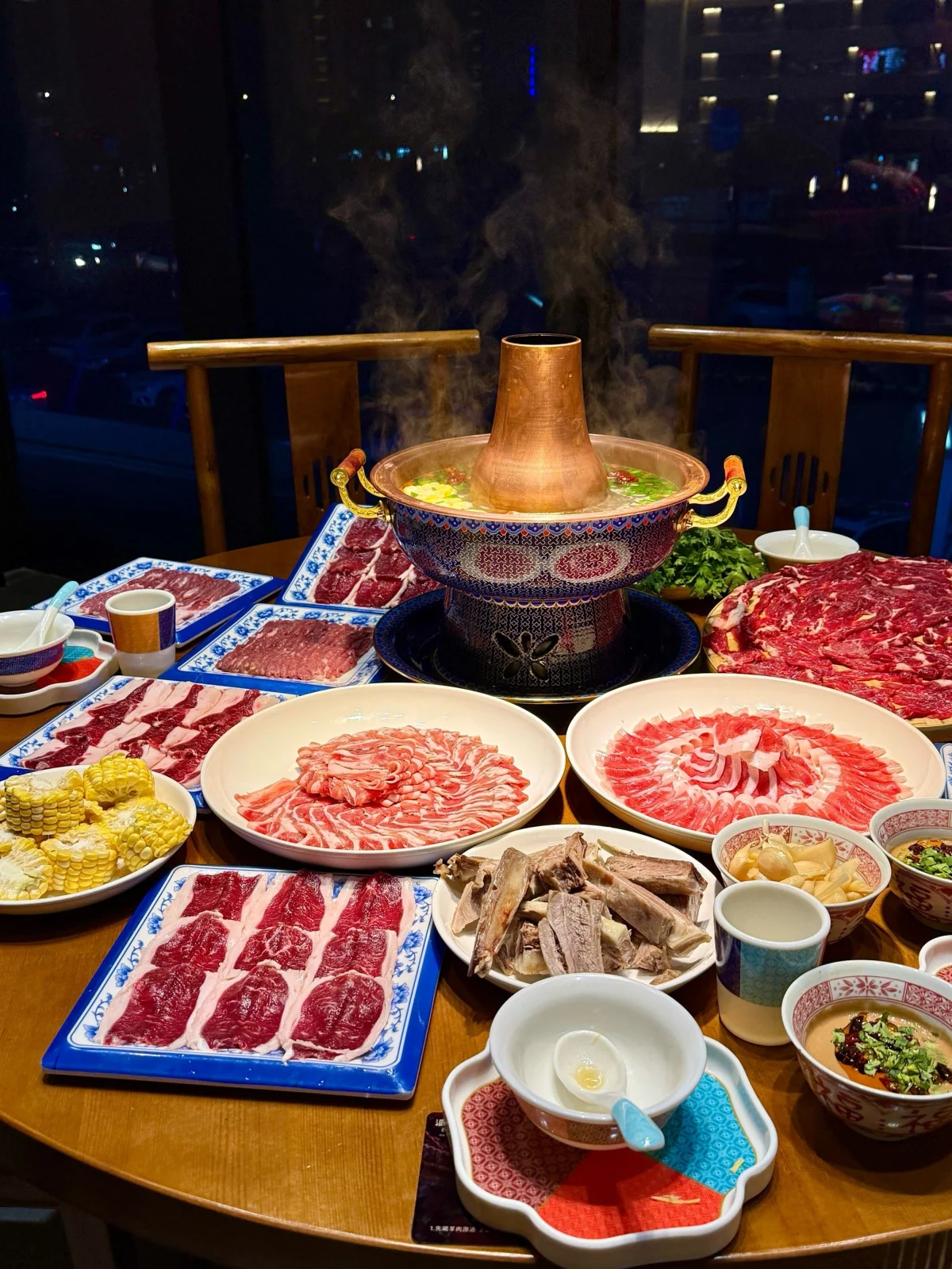Beijing copper hotpot spread with dipping sauce and sliced meat