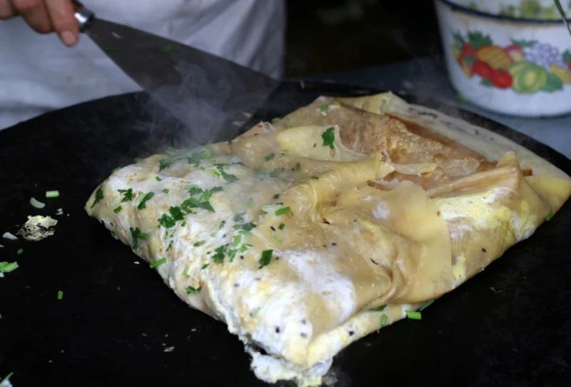 Freshly folded jianbing steaming on a hot griddle