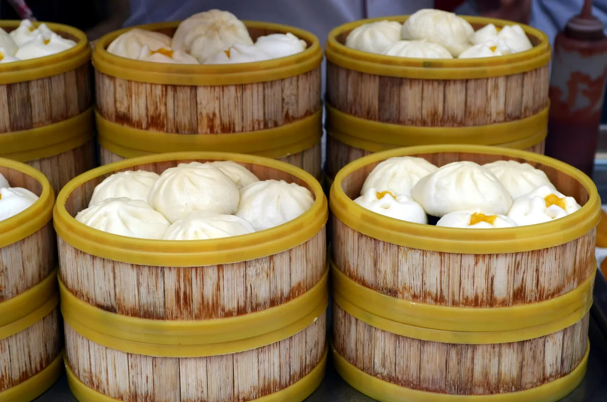 Steamed baozi served in bamboo baskets at a breakfast stall
