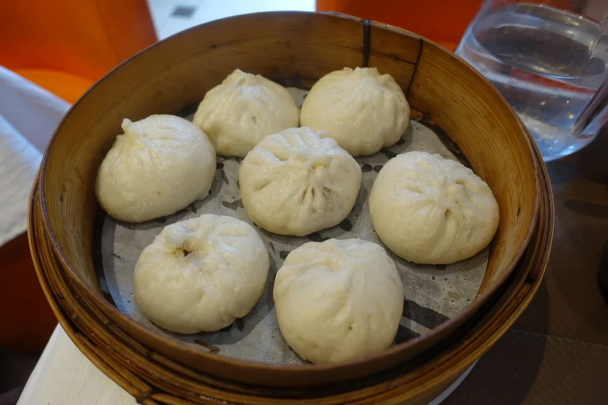 Fresh steamed baozi served together in a bamboo steamer basket