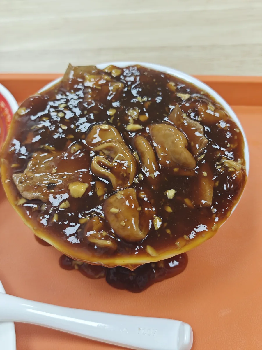 Glossy bowl of Beijing chaogan with pork liver, intestine, and chopped garlic