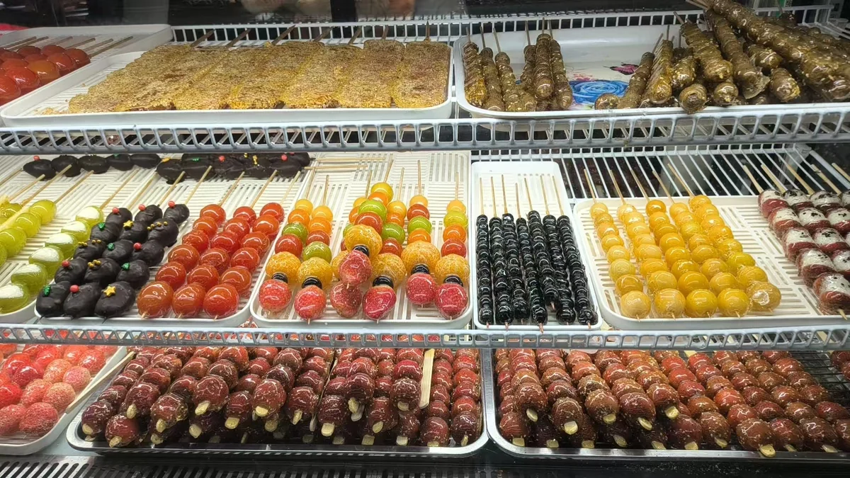 Winter tanghulu shop display with mixed fruit and hawthorn skewers