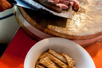 A bowl of luzhu huoshao showing chopped bread and braised offal in broth.