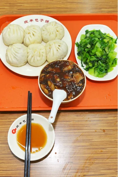 Beijing chaogan served with baozi, cilantro, vinegar, and chopsticks for breakfast