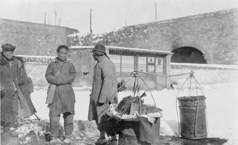 Historic Peking street vendor selling candied fruit skewers in winter