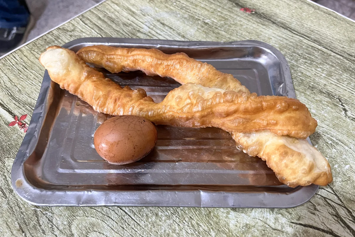 Fresh youtiao and tea egg served as practical sides for doufunao