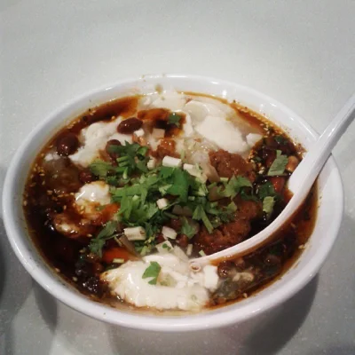 Beef doufunao showing a richer meat gravy style for savory tofu pudding