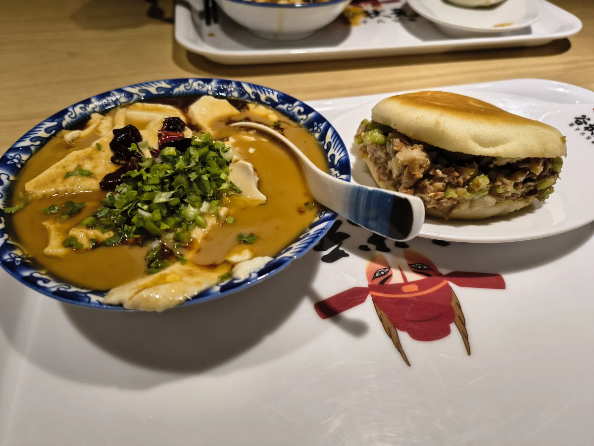Northern laodoufu bowl with stronger condiments beside a wheat snack