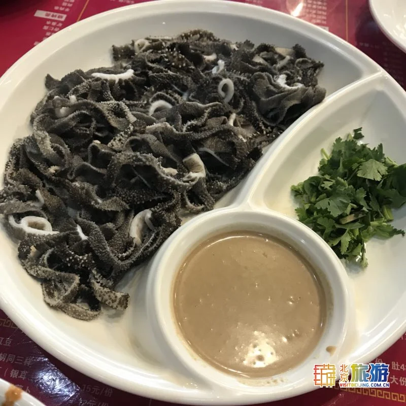 Plate of Beijing baodu with sesame paste sauce and chopped cilantro