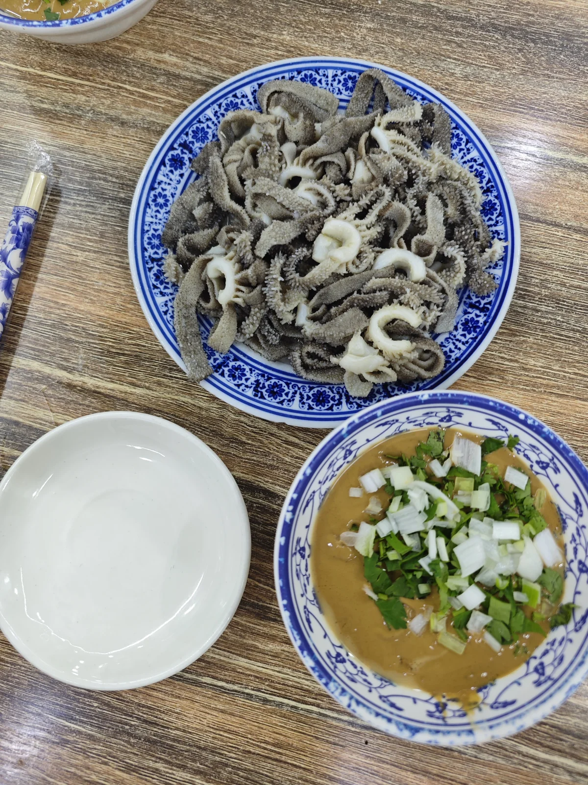 Old Beijing baodu served with sesame sauce, cilantro, and scallion