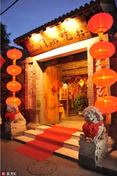 Old Beijing baodu shop entrance at night with red lanterns