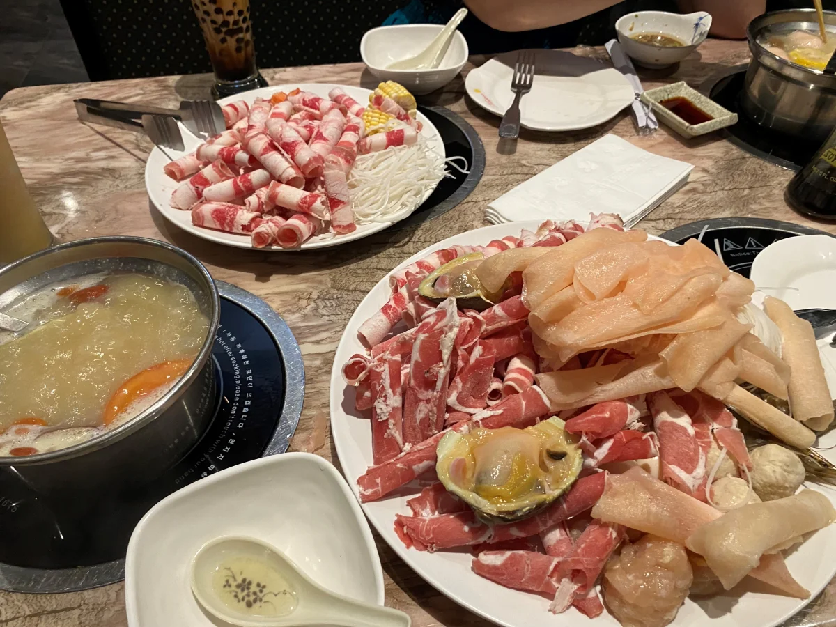 Hotpot table with meat and tripe ingredients for comparing baodu with hotpot tripe