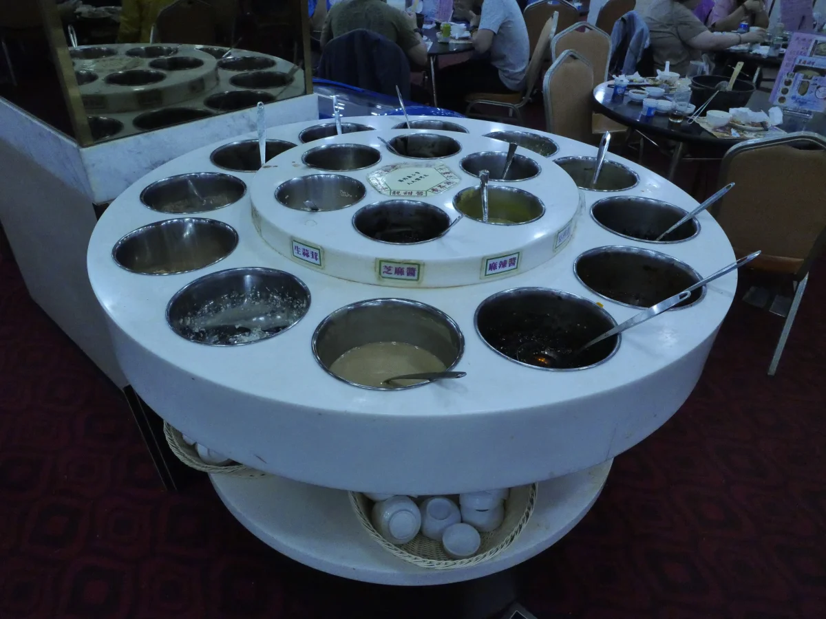 Hotpot sauce station showing sesame paste and condiments related to Beijing dipping sauce