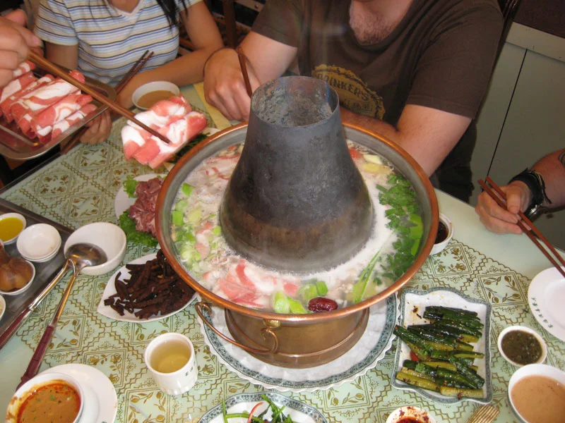 Copper hotpot table showing the shared hotpot setting that differs from baodu snack shops