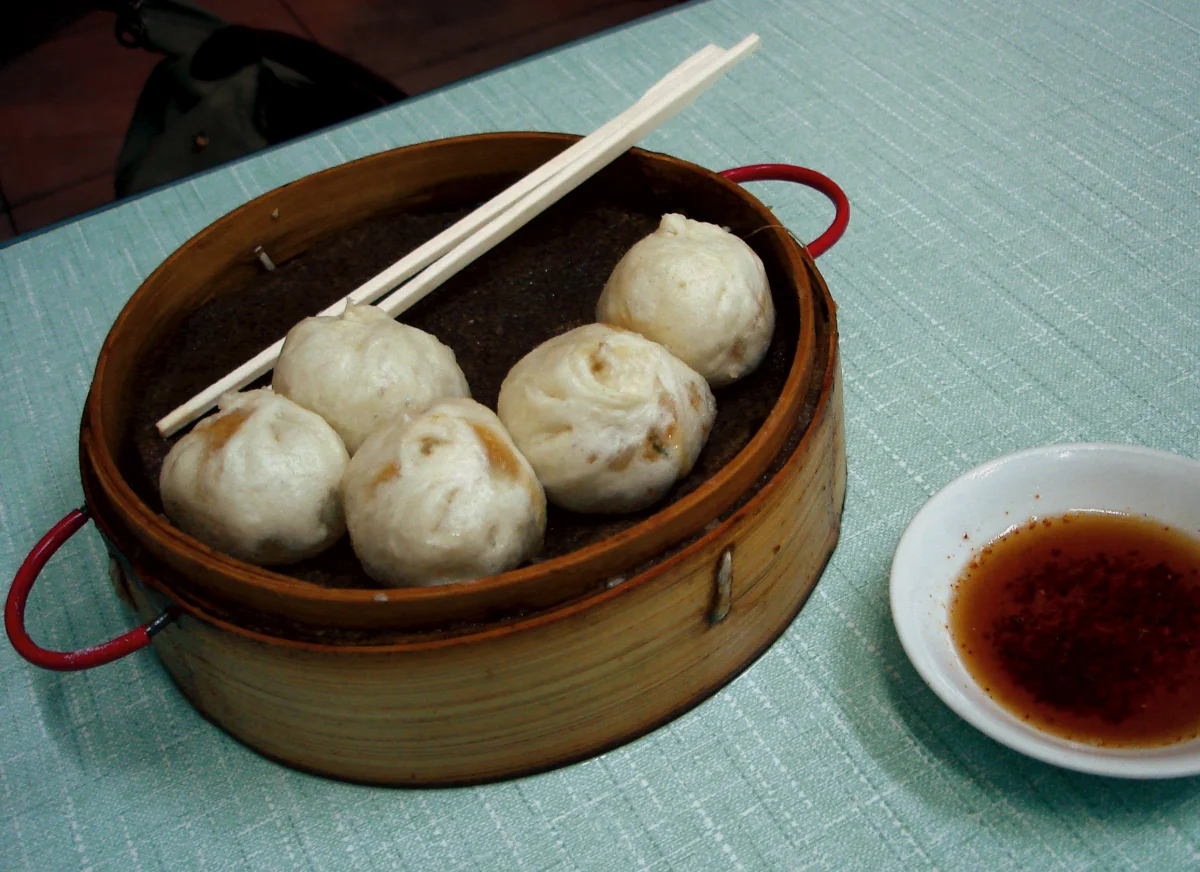 Beijing baozi steamed buns in a bamboo basket for comparison with meat pies