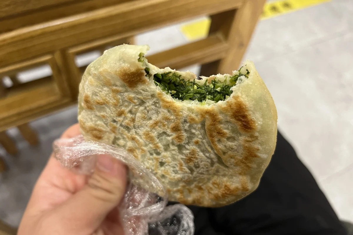 Bitten Beijing fennel xianbing showing vegetable filling and pan-fried wrapper