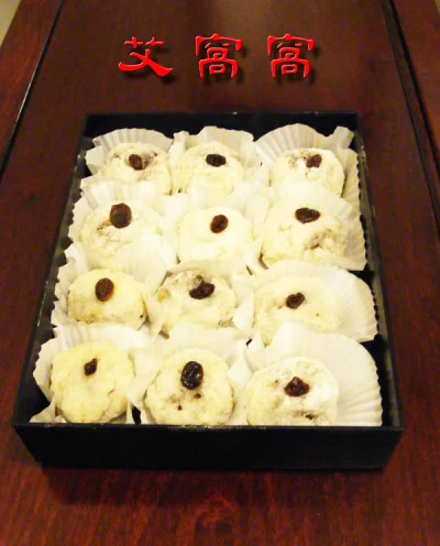 A tray of white Aiwowo-style glutinous-rice snacks topped with dark filling