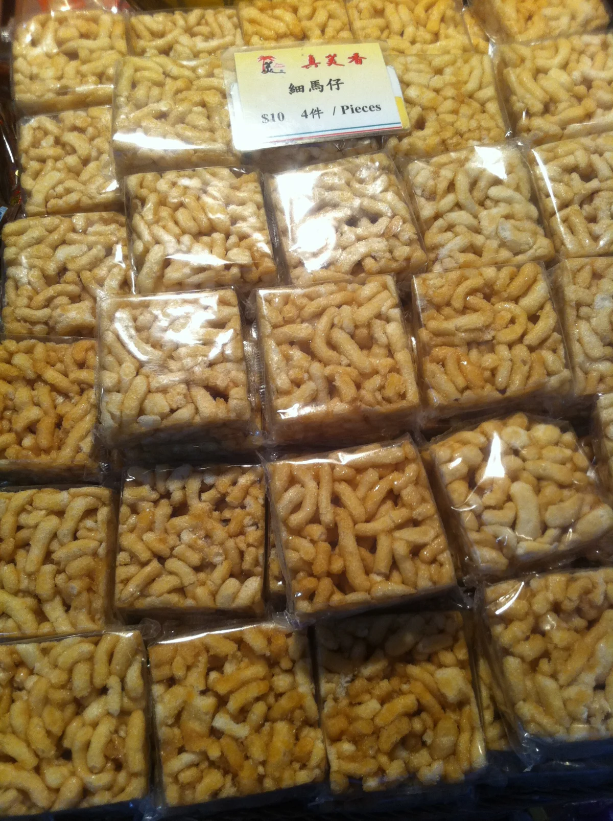 Packaged saqima displayed for sale, showing the snack's crisp noodle-strand texture