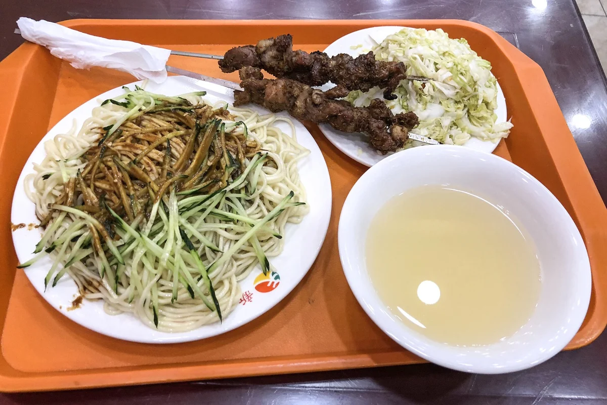 Beijing meal with lamb kebabs, cold noodles, noodle soup, and cabbage salad