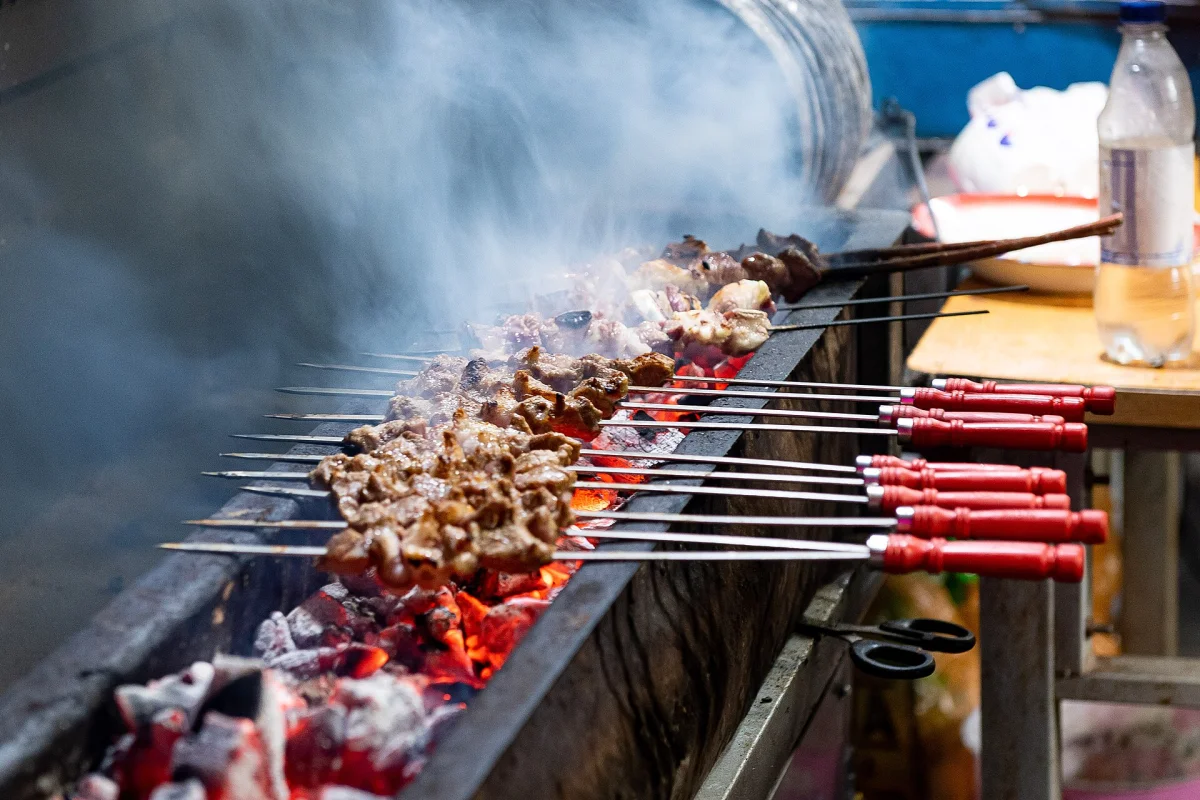 Lamb kebabs grilling over charcoal in Kashi