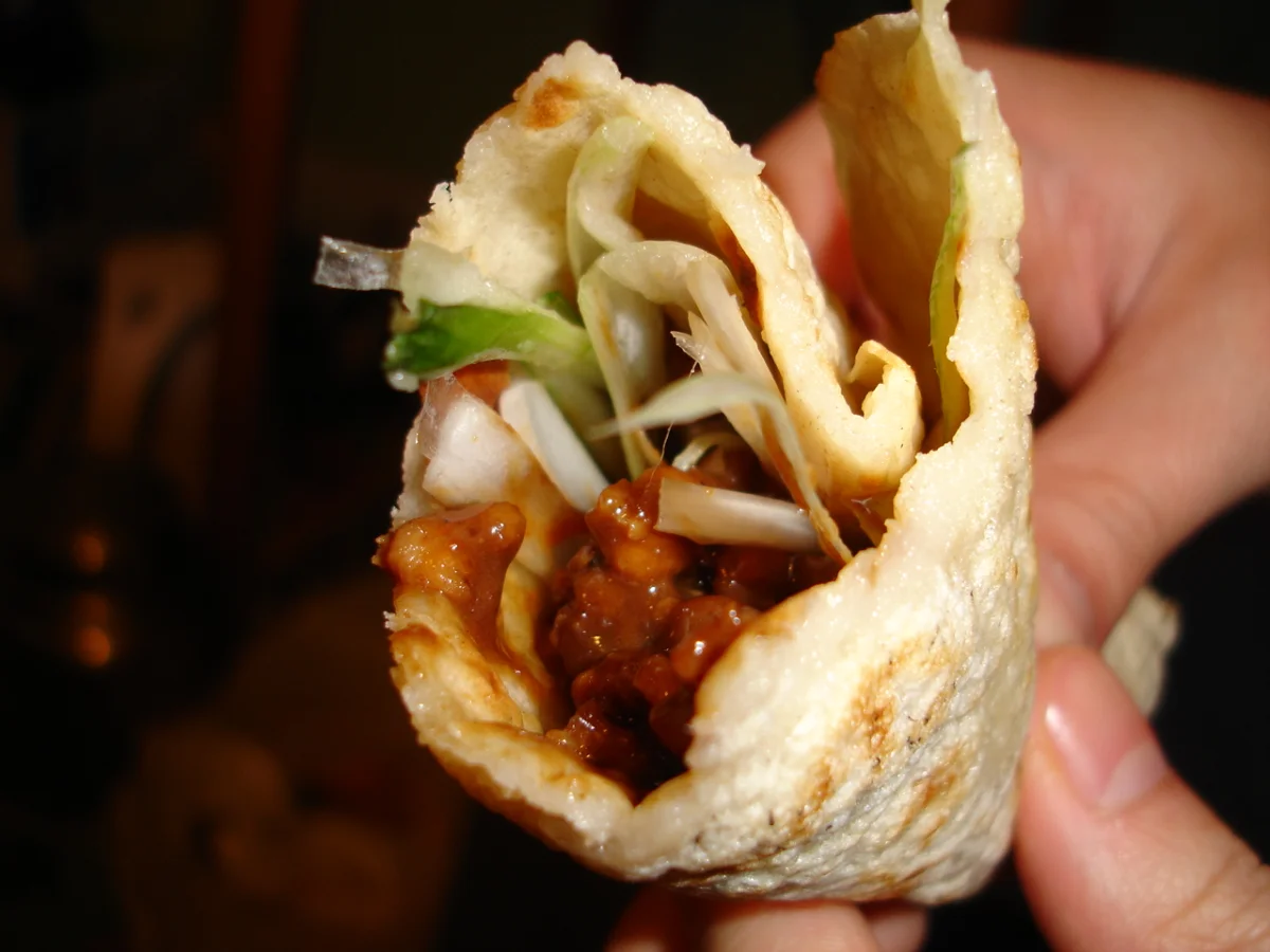 A tofu-skin wrap filled with Jing Jiang Rou Si and scallion