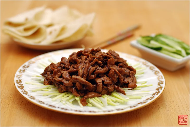 Jing Jiang Rou Si plated with fresh scallion and tofu skin
