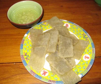 Fried Beijing guanchang slices on a patterned plate with garlic water