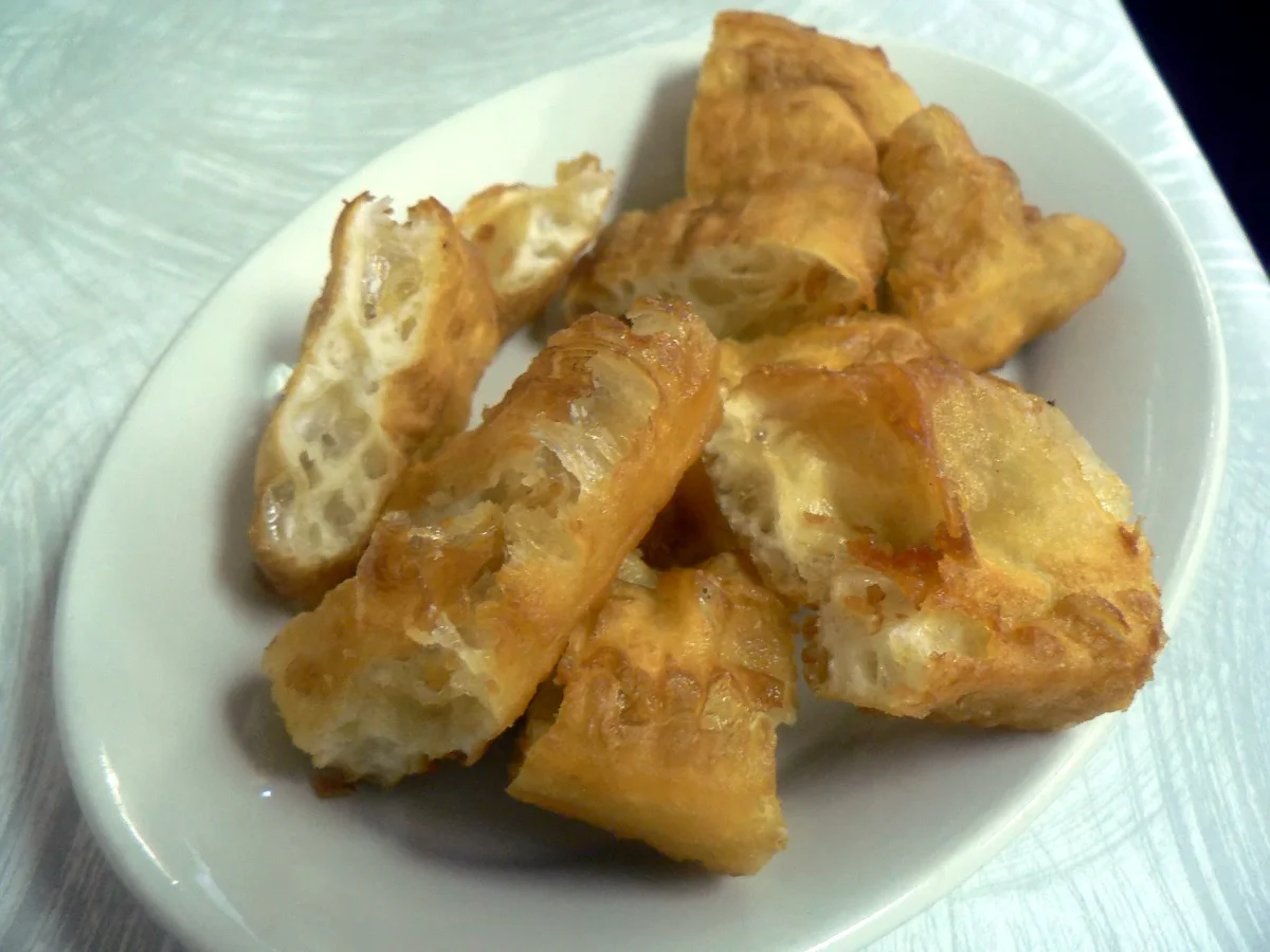 Pieces of Chinese fried bread showing the crisp shell and pale airy interior of youtiao.