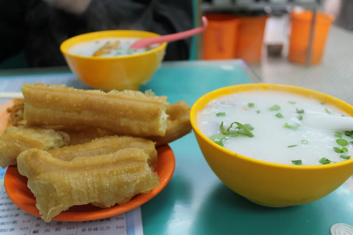 Youtiao served beside a bowl of congee, illustrating a warm breakfast pairing.