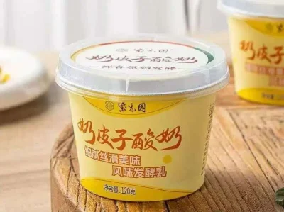 Yellow cup of chilled Beijing milk-skin yogurt with a creamy dairy top