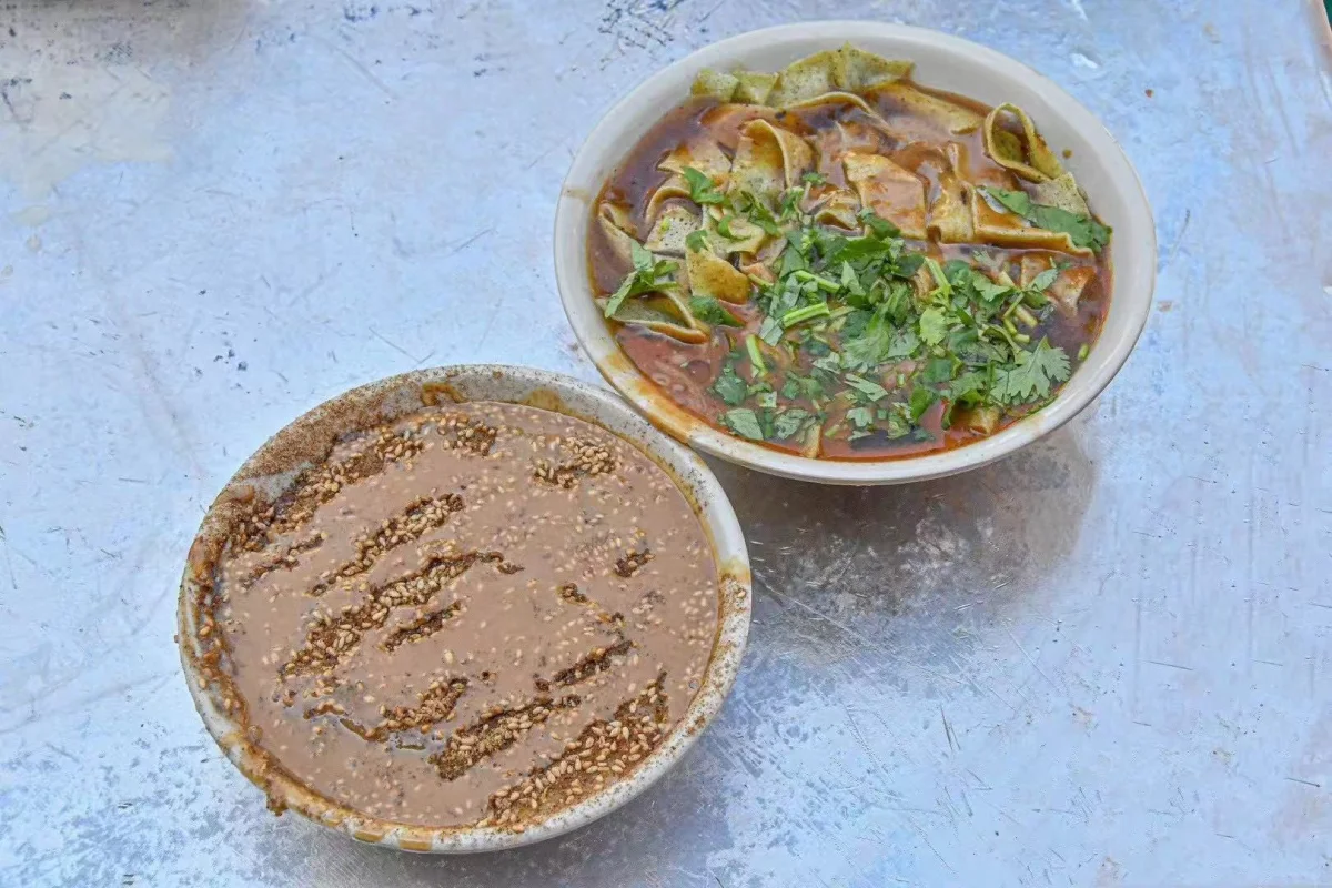 A bowl of sesame-topped miancha served beside a savoury breakfast bowl