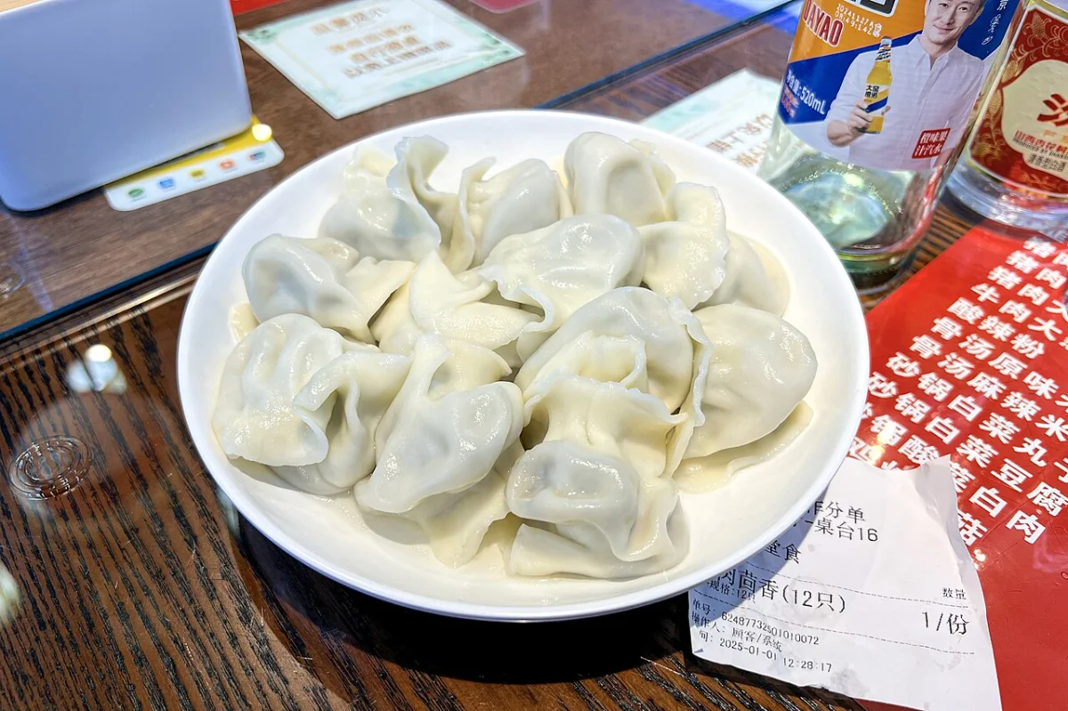 Pork-and-fennel dumplings on a plate at Xijiayuan, Baiqiao Dajie, Beijing, photographed in January 2025