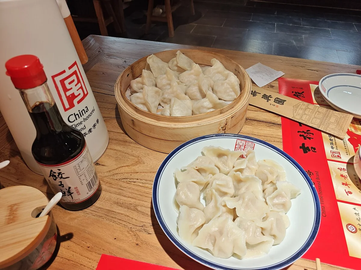 Steamed dumplings in a basket and boiled dumplings on a plate at Xinxingyuan in Changchun, photographed in March 2026