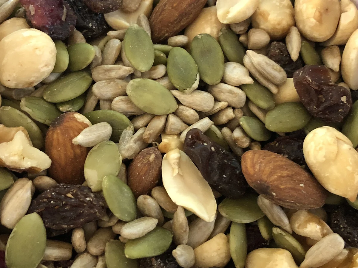 Nuts, seeds, and raisins representing optional saqima toppings and allergen questions