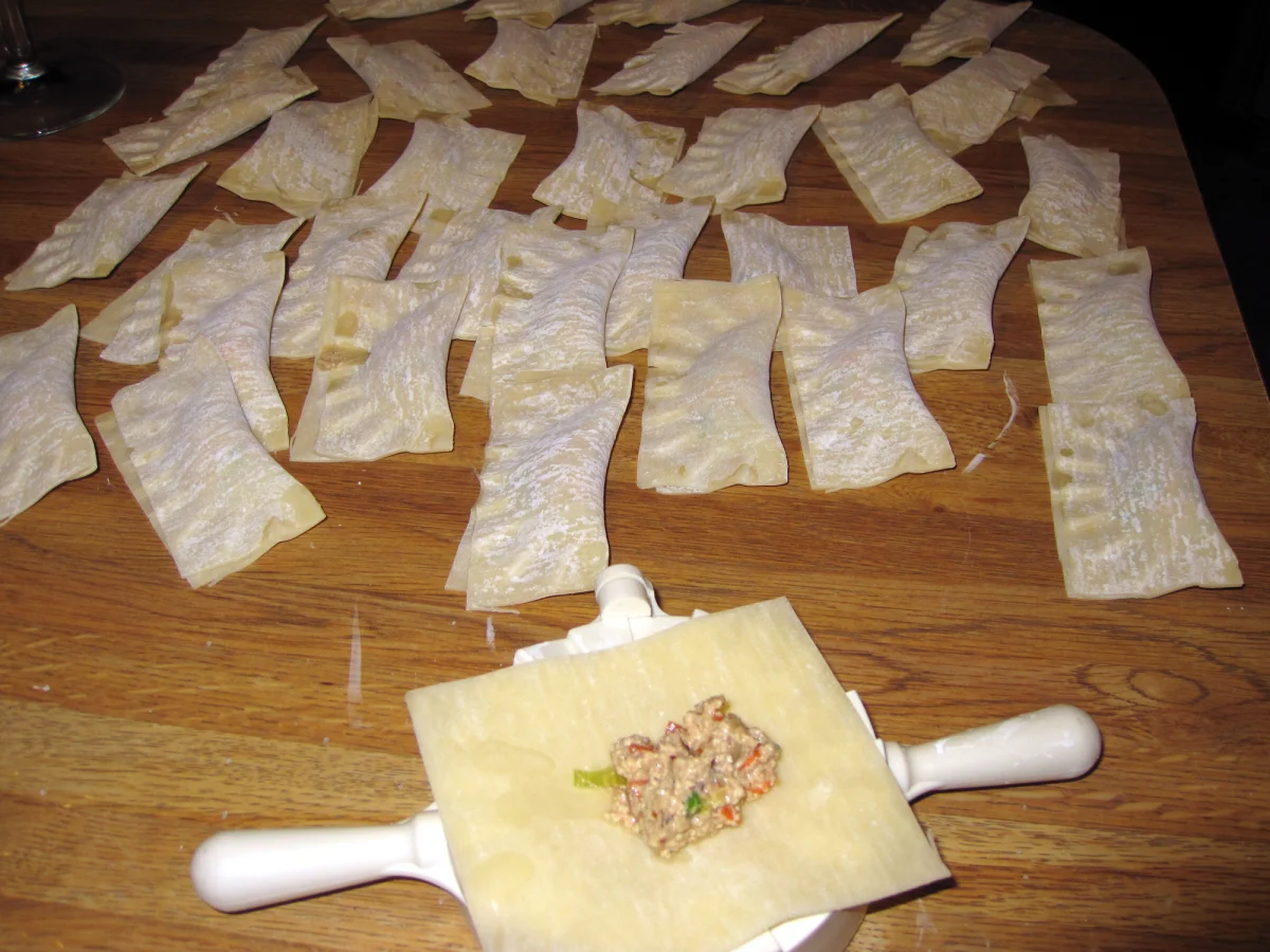 Thin dumpling wrappers laid out with filling before pan-frying