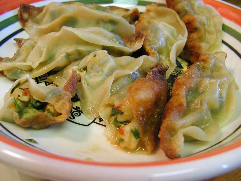 Plate of pan-fried potstickers with browned bases and tender wrappers