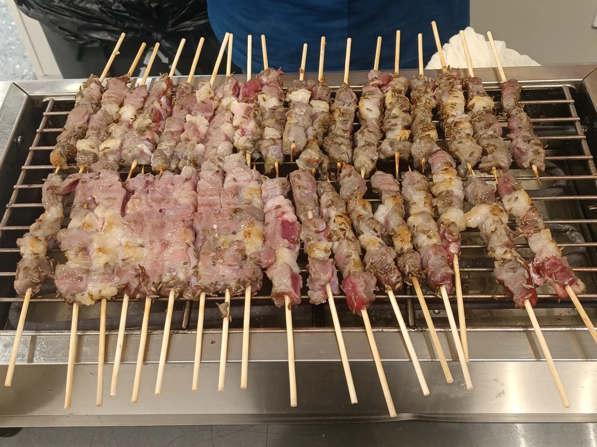 Lamb skewers arranged across a grill at Freshippo