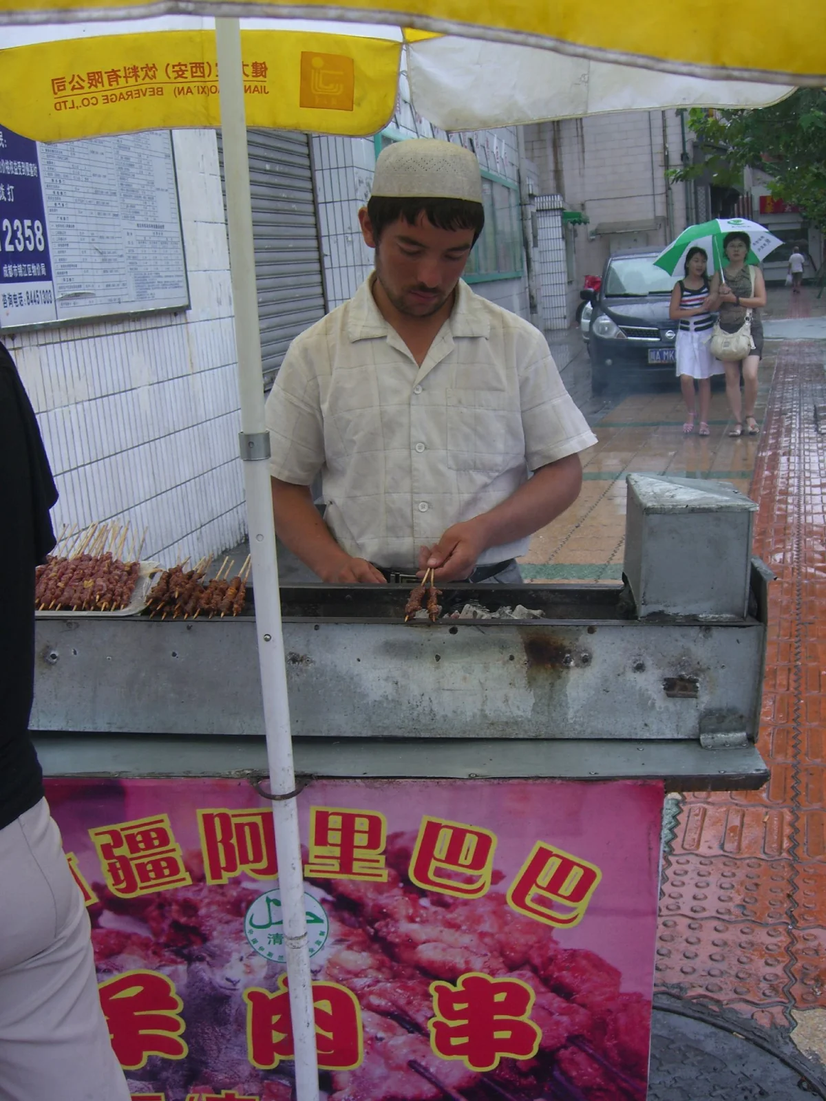 A cook grilling skewers at a Xinjiang Ali Baba food stall